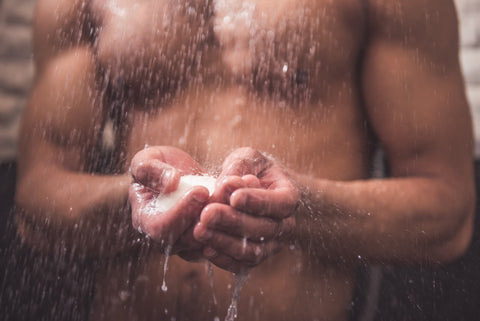 Man in shower with natural soap bar