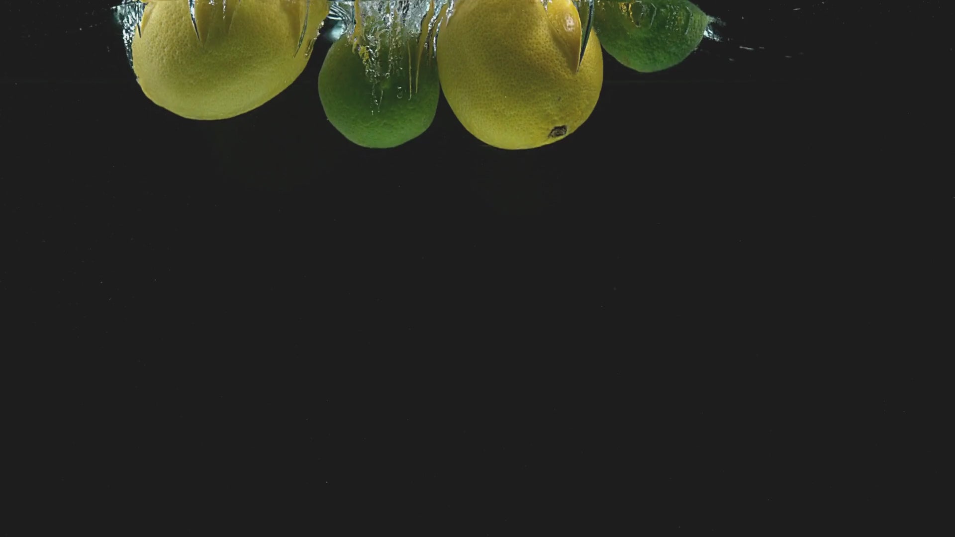 lemons and limes falling into water