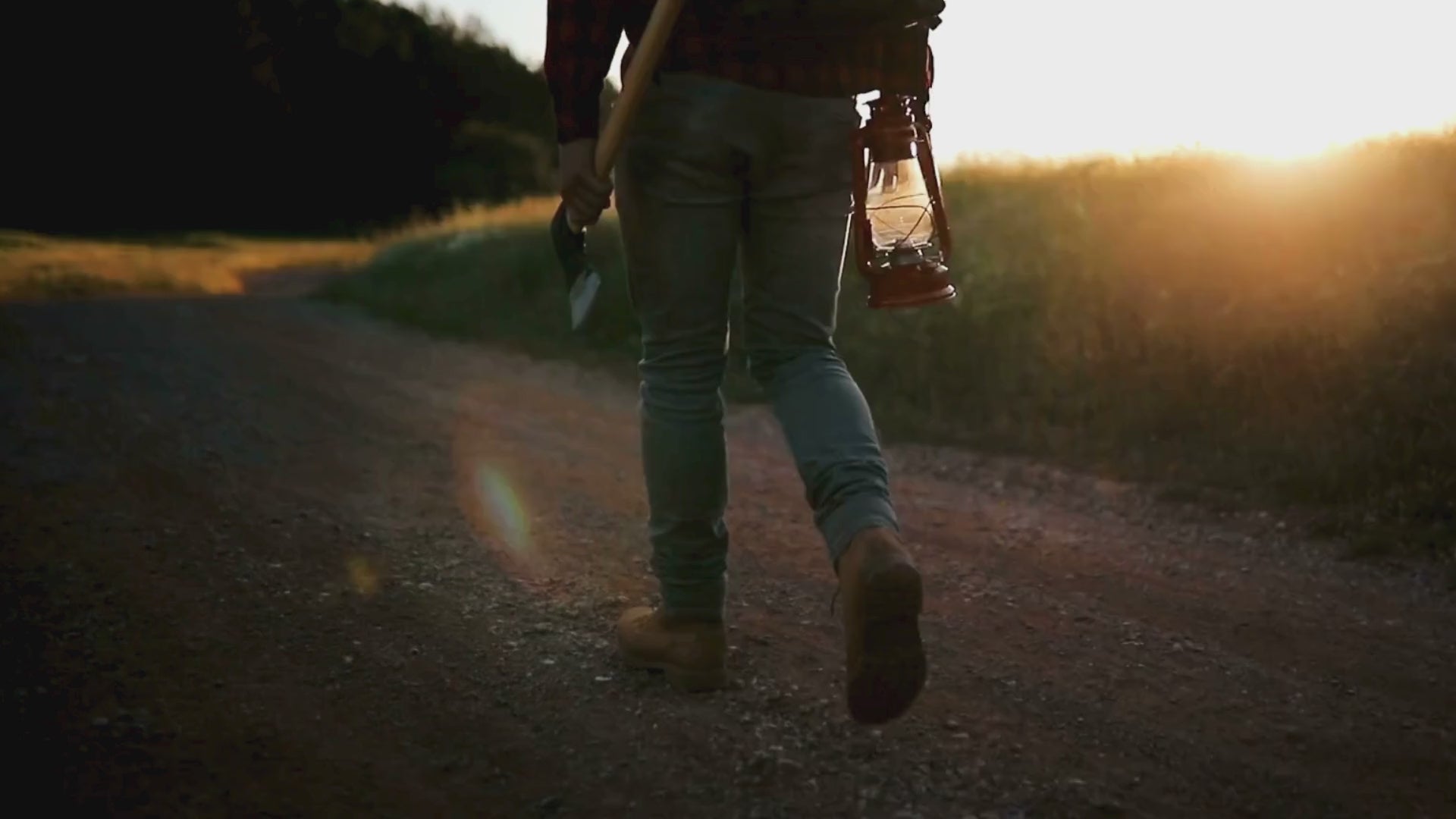 Man walking on dirt road with lantern